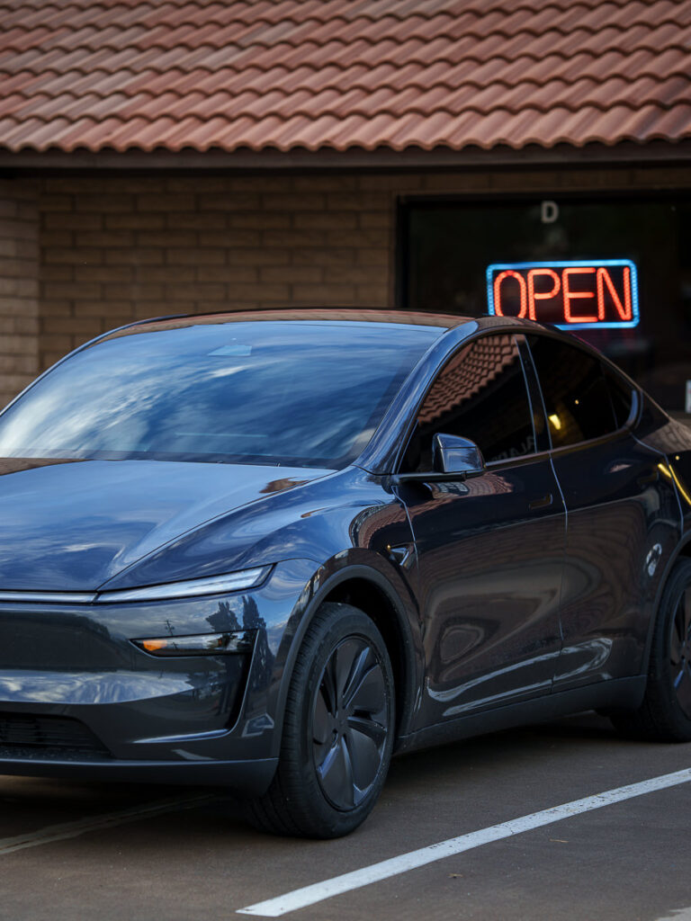 Gray Tesla Model Y with tinted windows outside Aladdins Window Tinting in Peoria, Arizona
