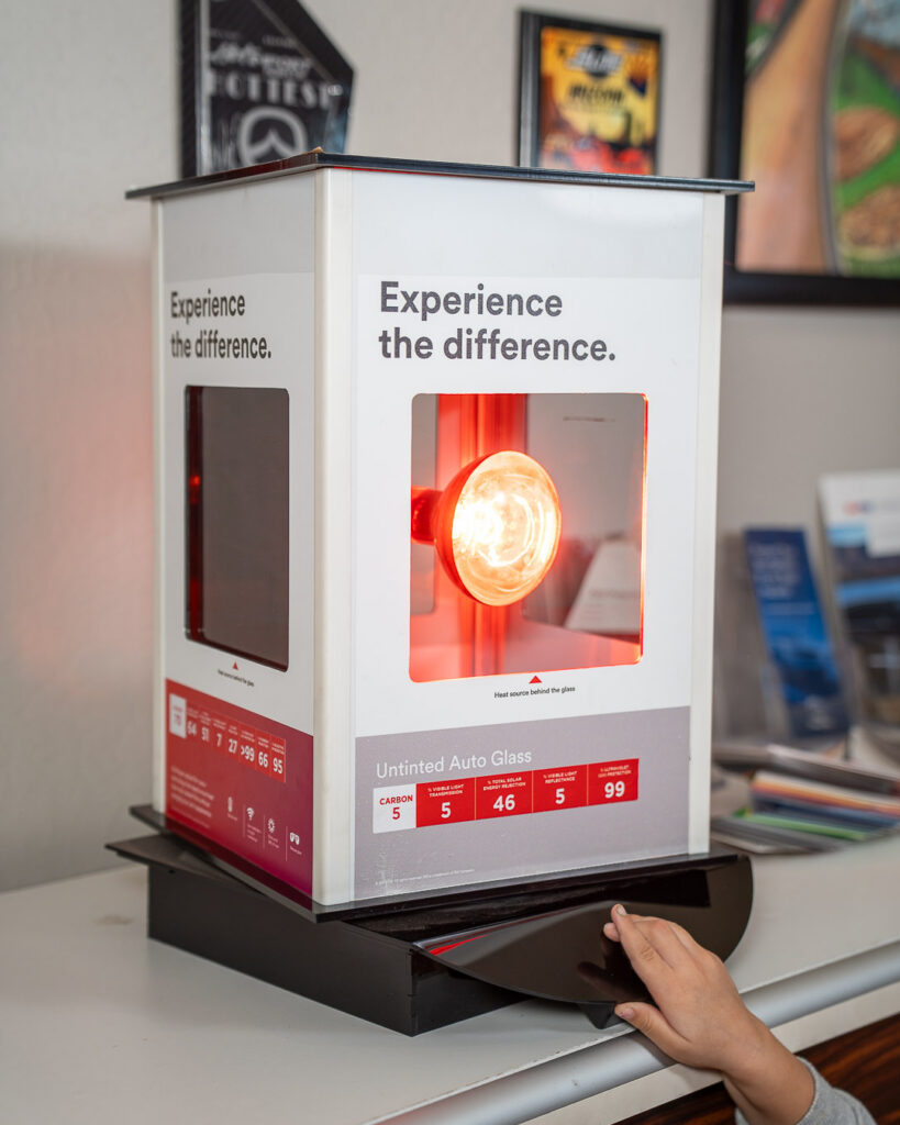 Heat lamp display for comparing carbon vs ceramic window tint at Aladdins Window Tinting.