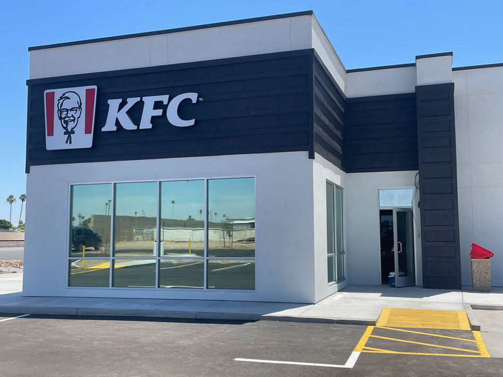 KFC restaurant exterior with reflective tinted storefront windows.