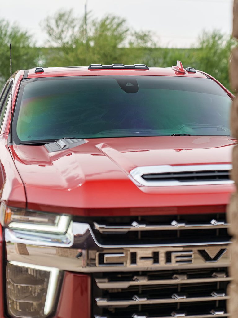Front view of a red Chevrolet pickup truck with a dark tinted windshield.