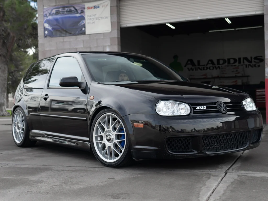 Black Volkswagen Golf R32 with silver wheels parked outside the Aladdins Window Tinting shop.