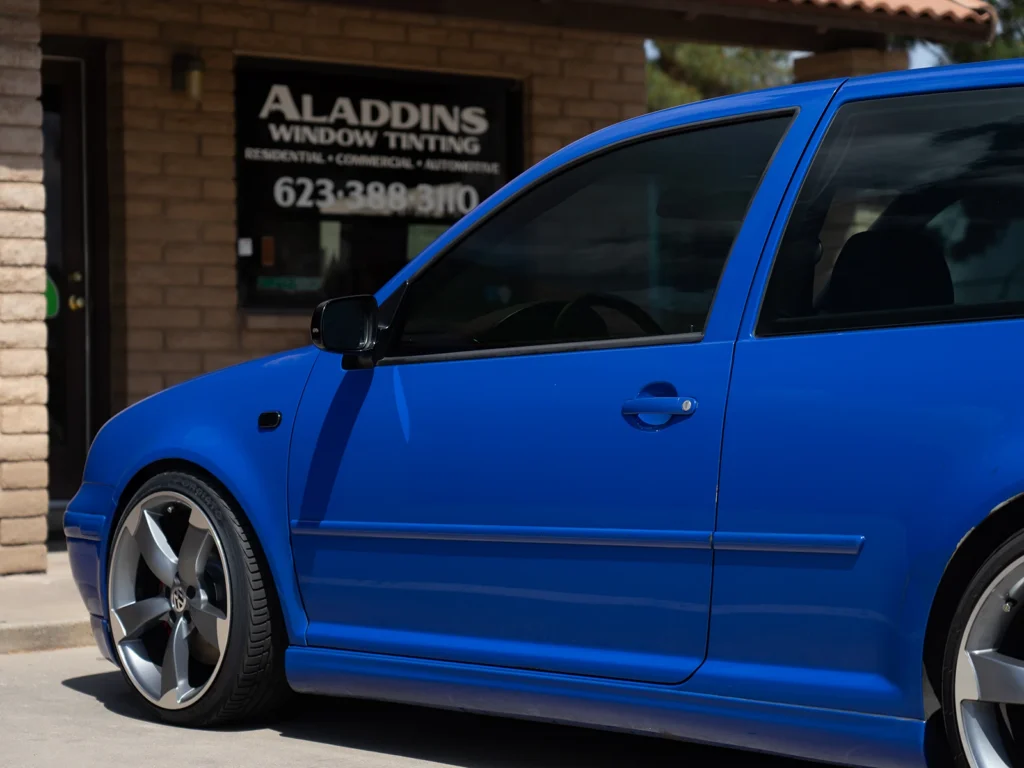 Blue Volkswagen Golf R32 with SunTek Carbon 35% window tint parked outside Aladdins Window Tinting.